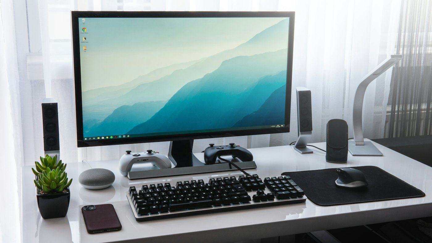 Aufgeräumter Arbeitsplatz mit Monitor, Tastatur und Zubehör